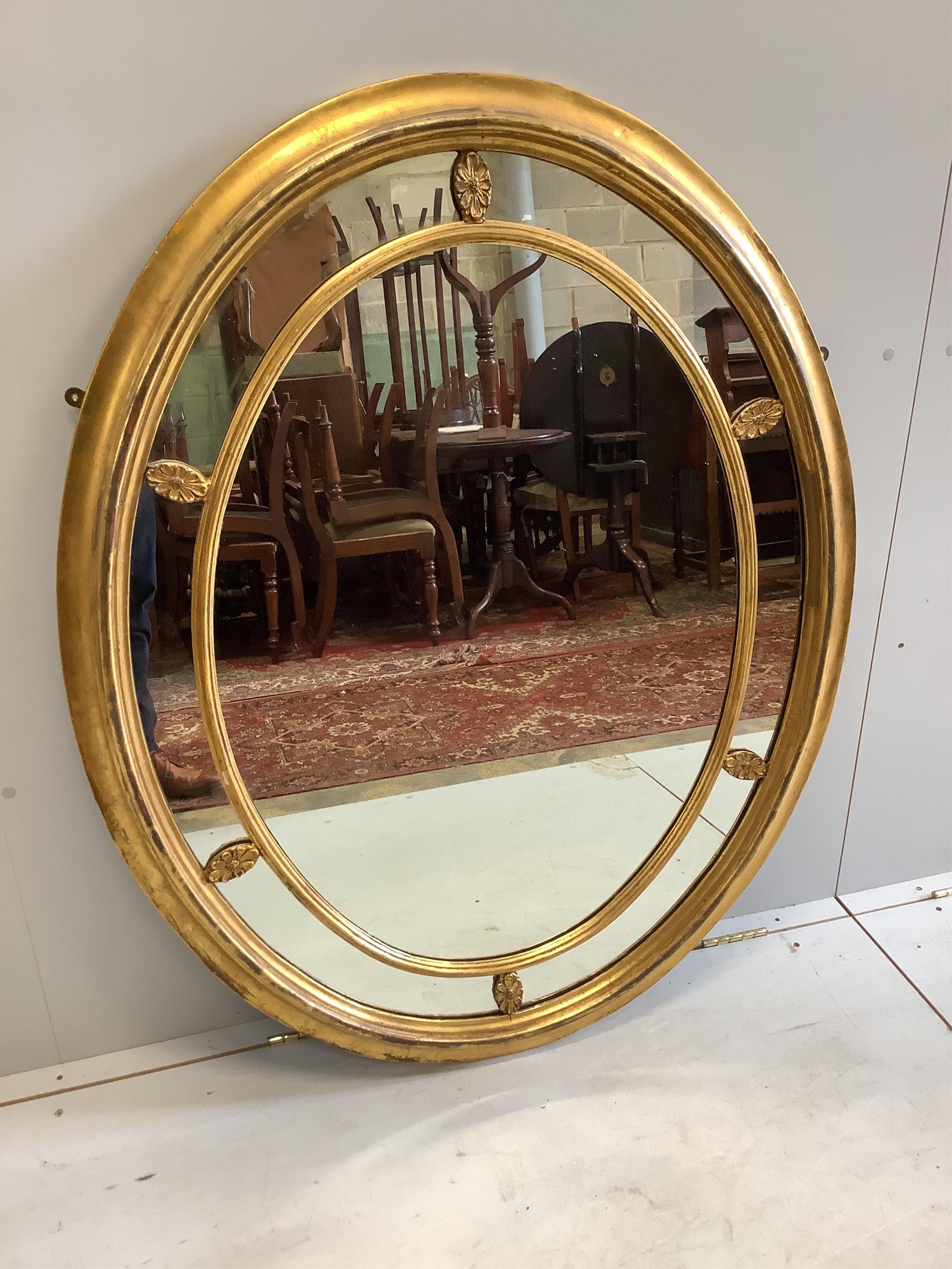A George III style oval giltwood marginal plate wall mirror, width 98cm, height 125cm. Condition - fair